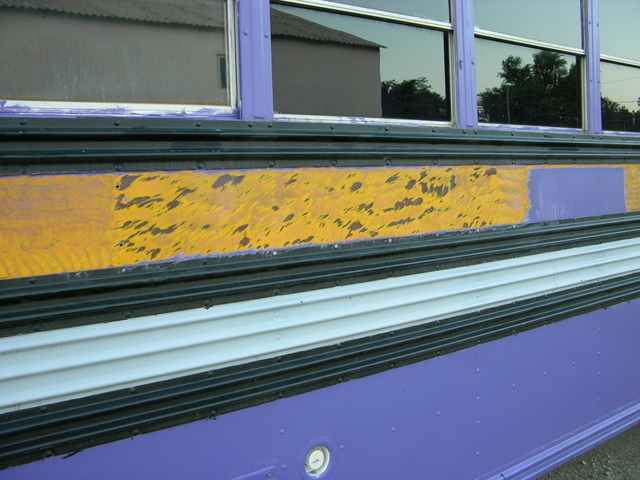 Purple paint stripped from schoolbus with fine wire wheel on angle grinder