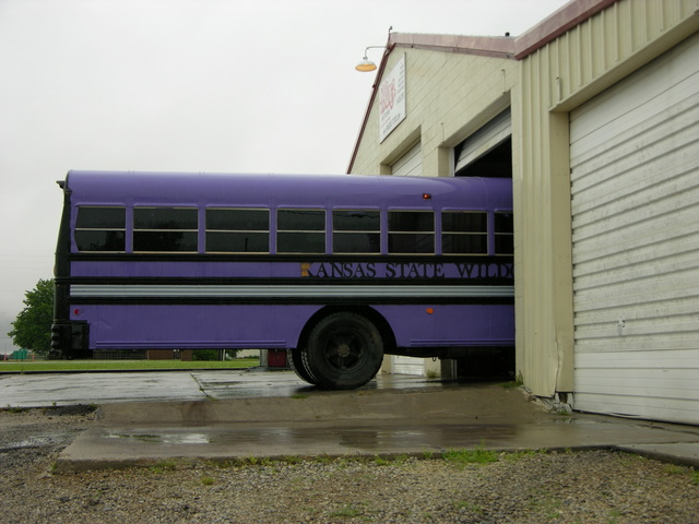 Purple schoolbus pulled into shop for engine cleaning