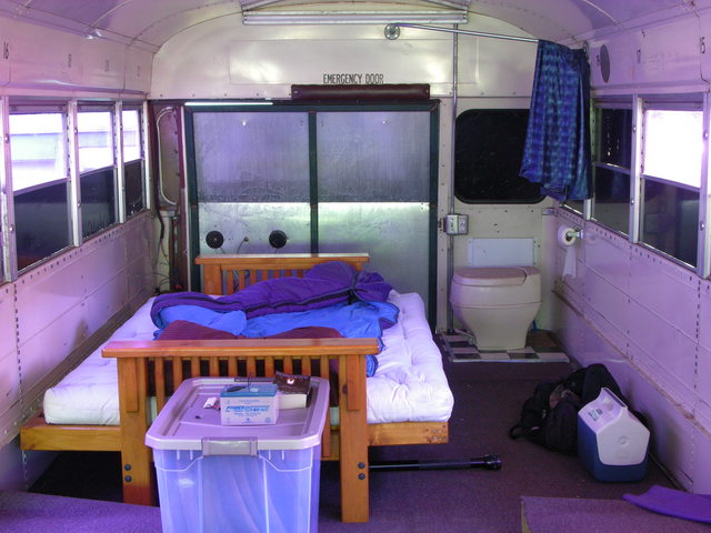 Rear interior of schoolbus RV with futon