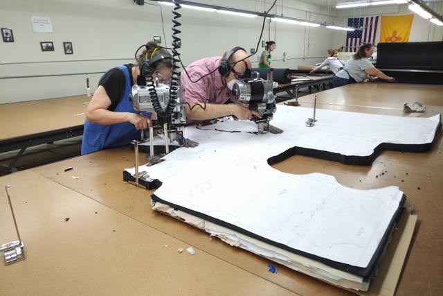 cutting fabric at Albuquerque Fashion Incubator